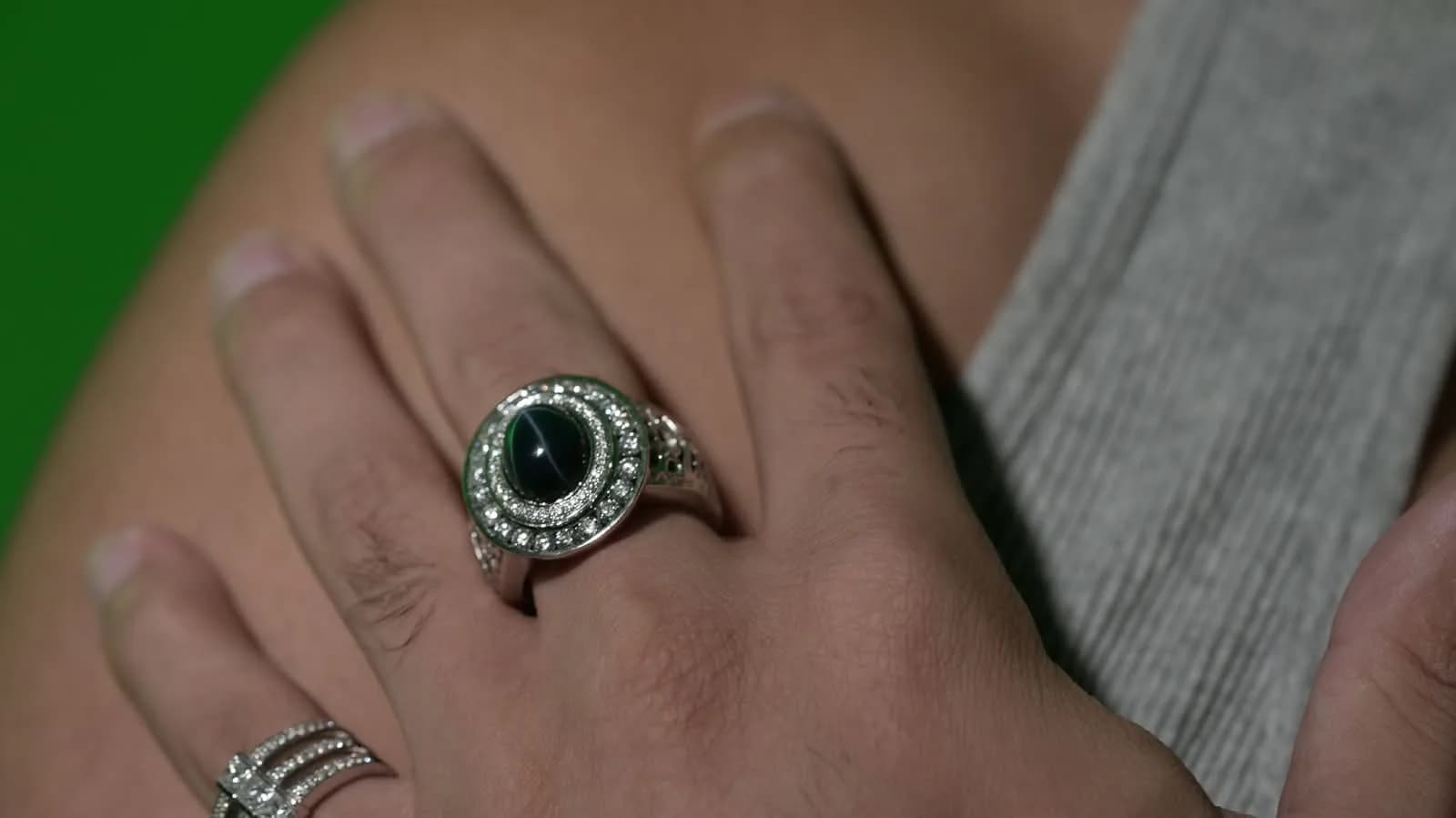 Mozafarian statement ring with a dark center stone and pavé halo