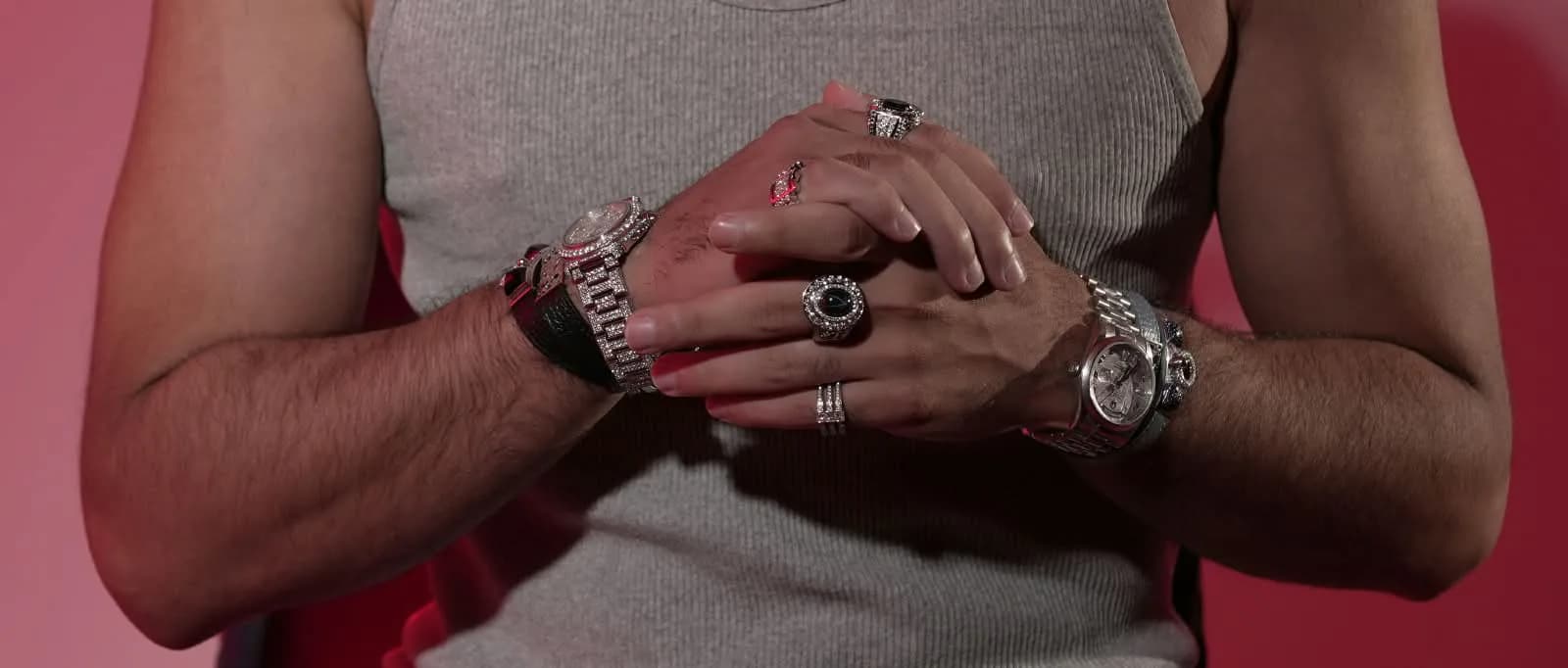 Hands, rings, bracelets and watches styled against a red studio backdrop